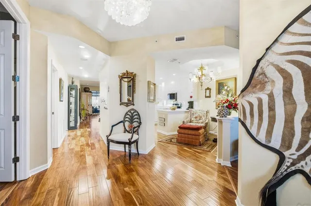 a view of a hallway with furniture and wooden floor