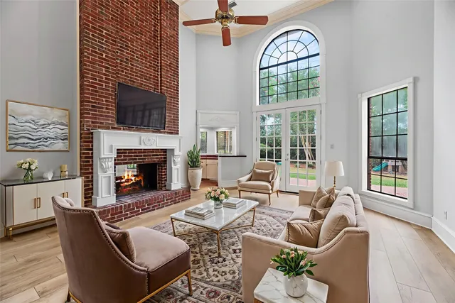 a living room with furniture a fireplace and a floor to ceiling window
