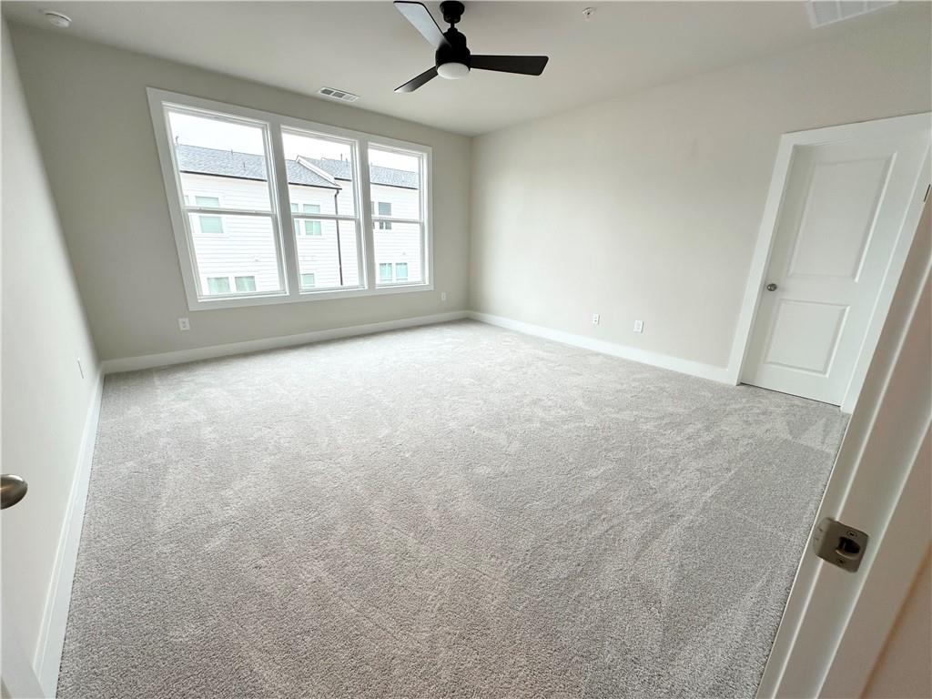 1237 Waldon Crossing Cumming, GA 30041 - Photo 11 of 29 an empty room with windows and ceiling fan