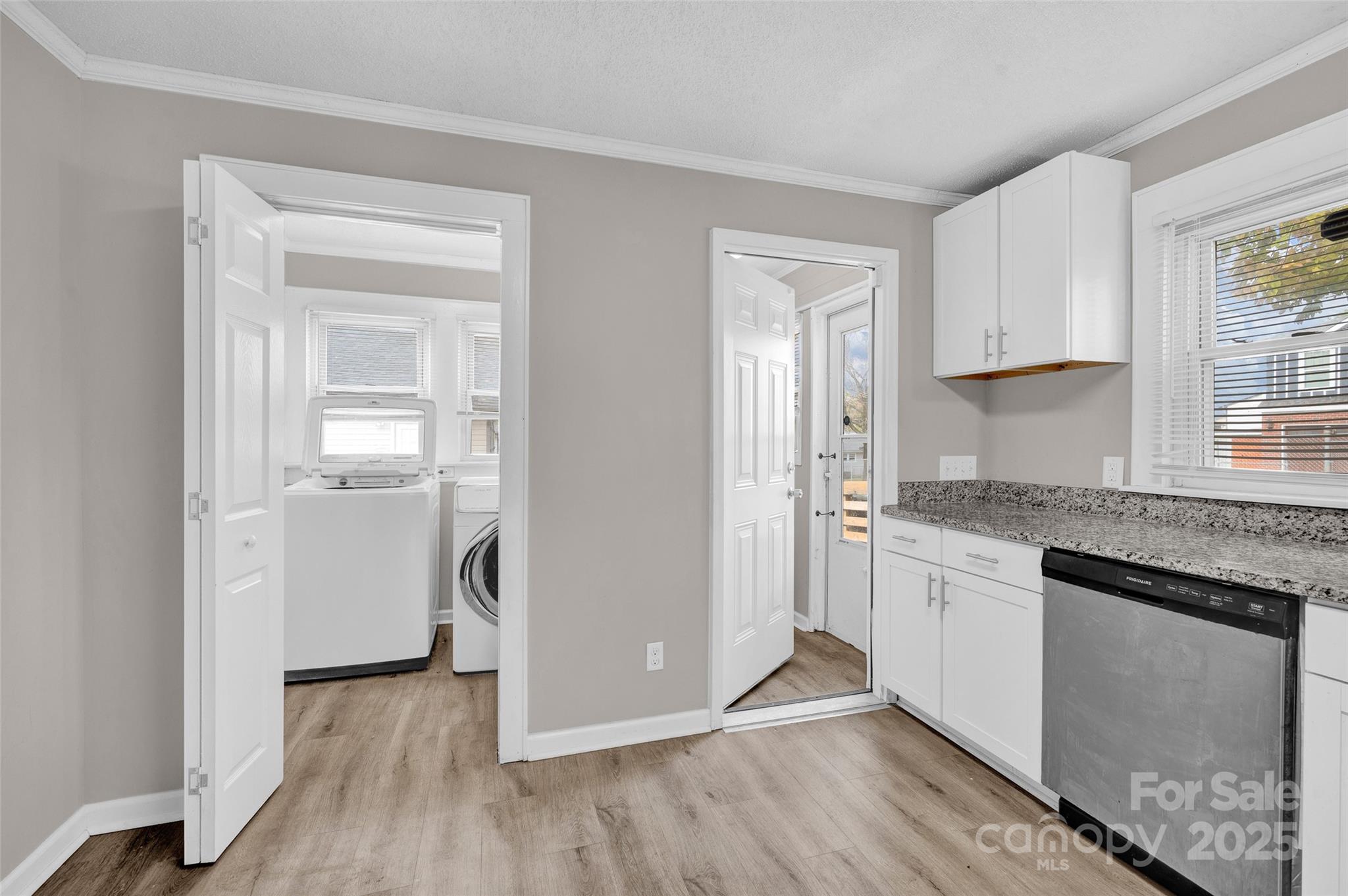 144 Robbins Street Southwest Concord, NC 28025 - Photo 11 of 29 a hallway with cabinets wooden floor and a window