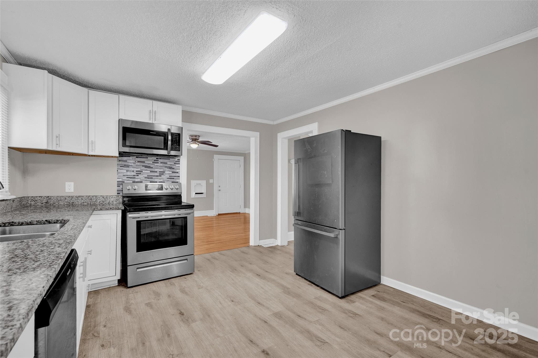 144 Robbins Street Southwest Concord, NC 28025 - Photo 13 of 29 a kitchen with granite countertop a refrigerator and a stove top oven