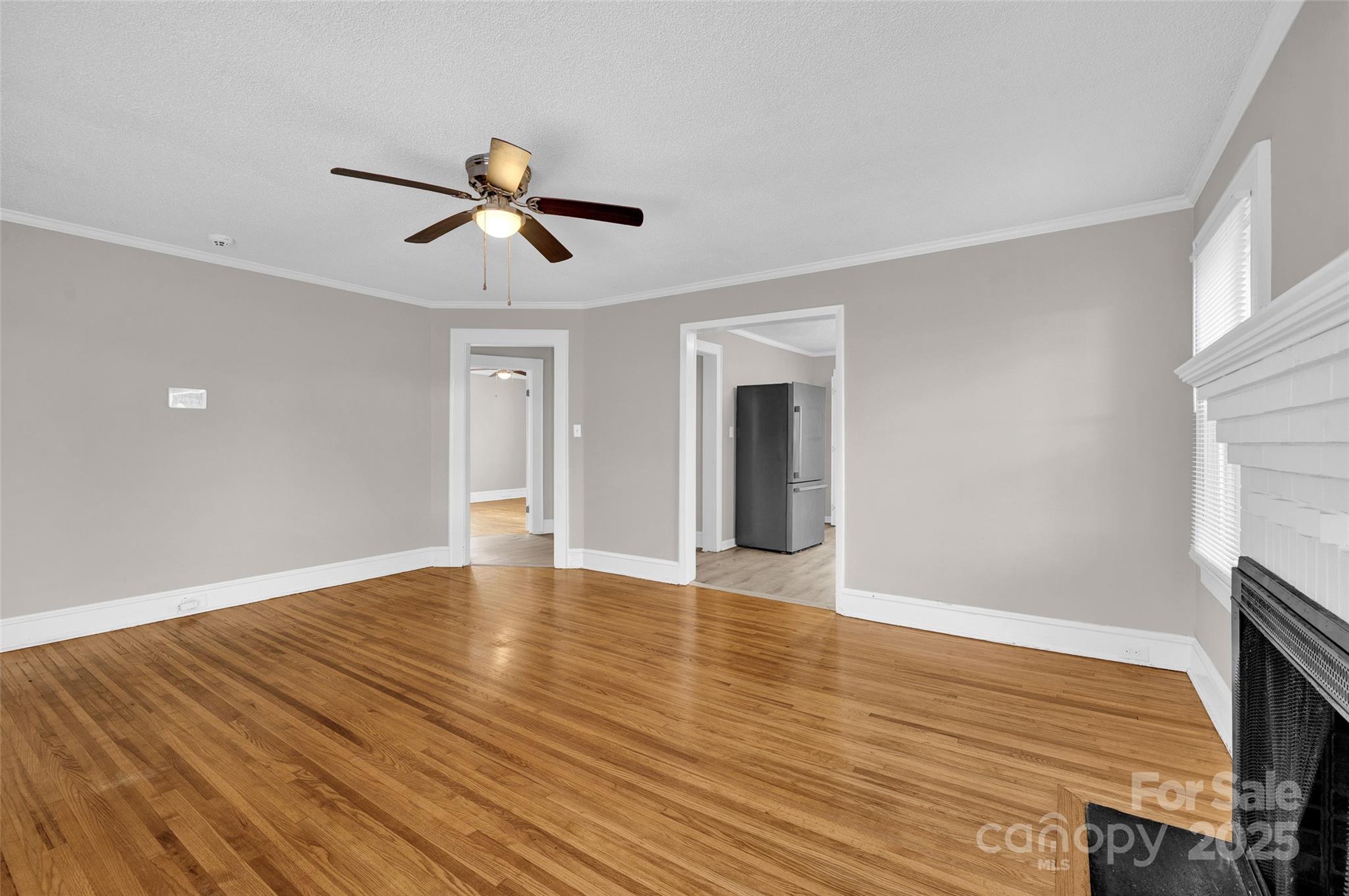 144 Robbins Street Southwest Concord, NC 28025 - Photo 8 of 29 a view of empty room with wooden floor and fan