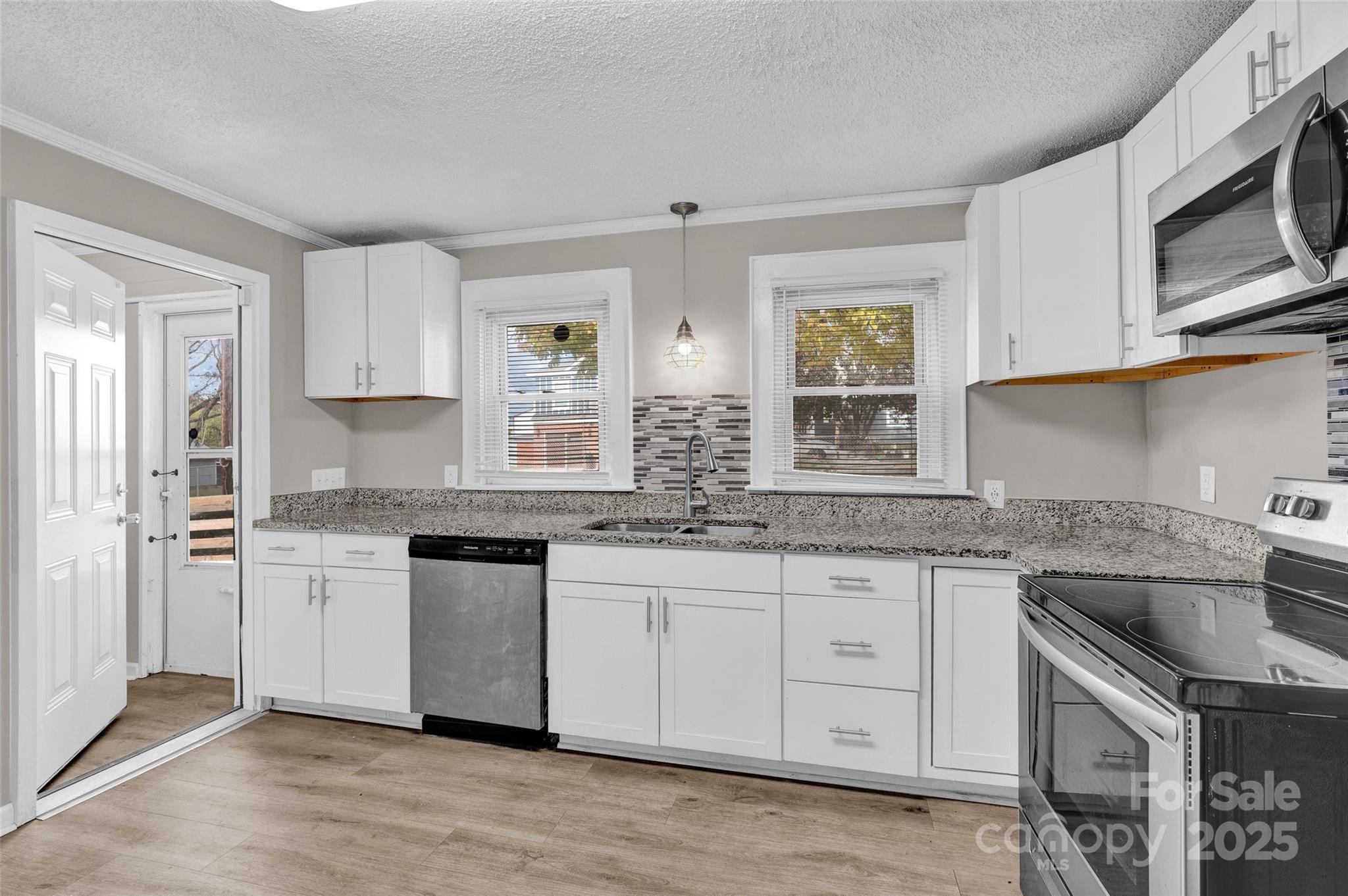 144 Robbins Street Southwest Concord, NC 28025 - Photo 10 of 29 a kitchen with granite countertop white cabinets white stainless steel appliances a sink and dishwasher