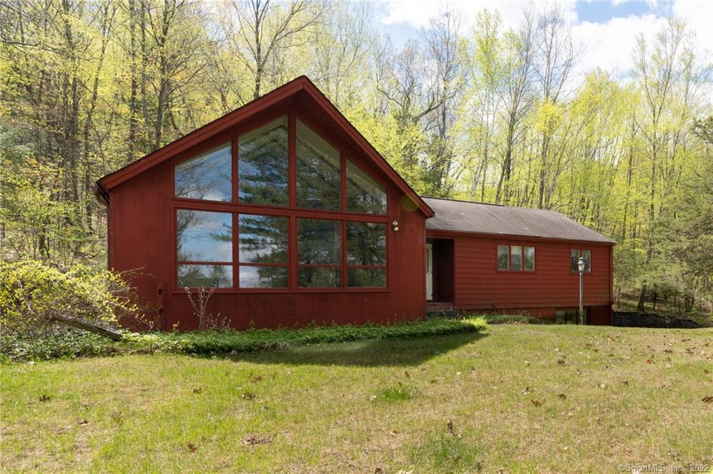 a view of brick house with a yard