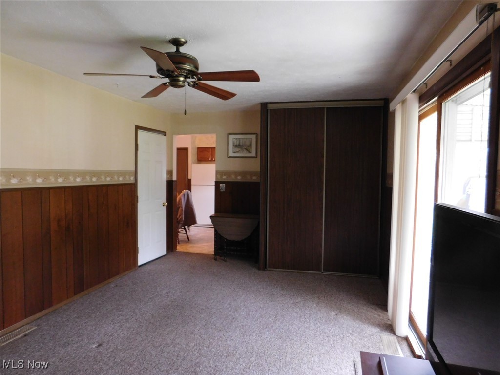 9255 Root Road North Ridgeville, OH 44039 - Photo 12 of 46 Unfurnished bedroom featuring wood walls, light carpet, multiple windows, and a wainscoted wall