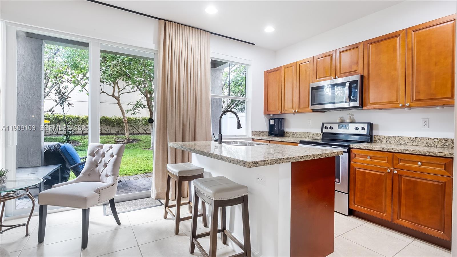 4445 Northwest 48th Terrace Tamarac, FL 33319 - Photo 7 of 19 a kitchen with stainless steel appliances granite countertop sink stove top oven and cabinets