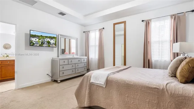 a bedroom with a bed a dresser and next to a window