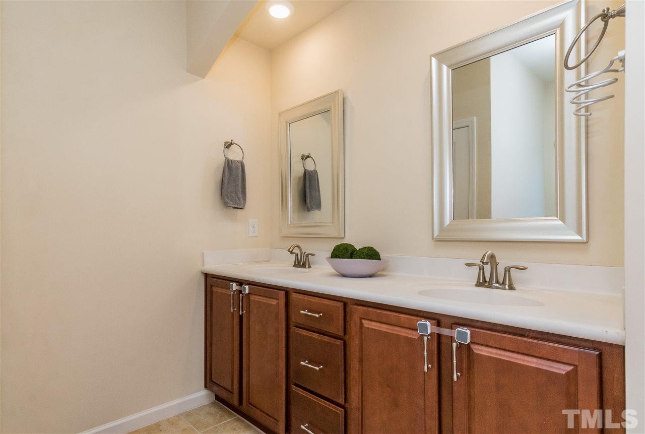 706 Edgewater Ridge Court Apex, NC 27523 - Photo 14 of 25 a bathroom with a double vanity sink and mirror