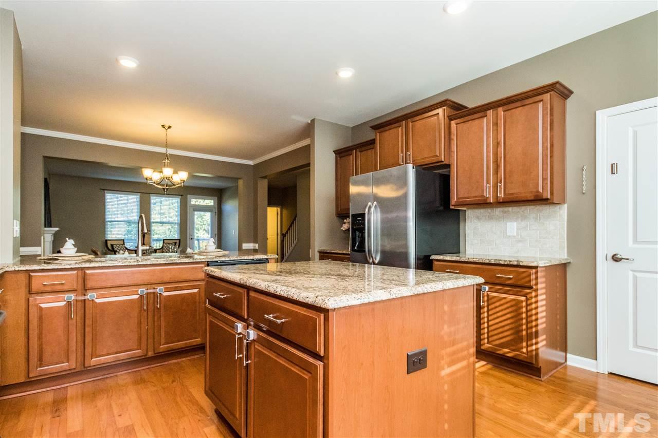 706 Edgewater Ridge Court Apex, NC 27523 - Photo 4 of 25 a kitchen with stainless steel appliances granite countertop a sink stove and refrigerator