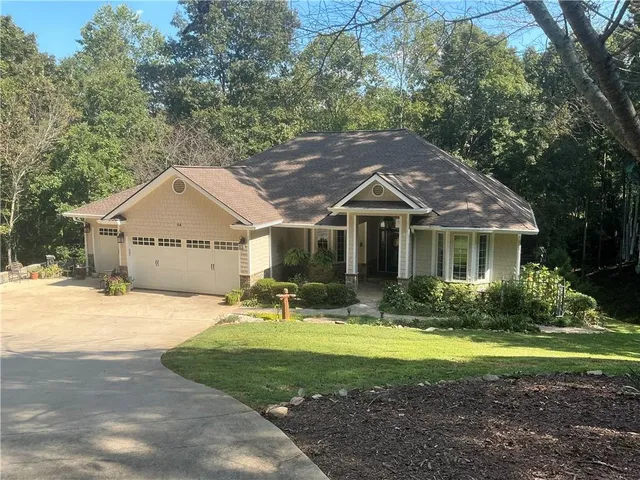 a balcony with table and chairs with wooden fence and plants