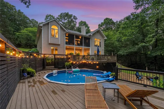 a dining room with wooden floor a chandelier a wooden table and chairs