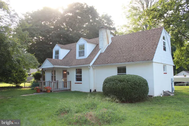 a view of a house with a backyard and trees