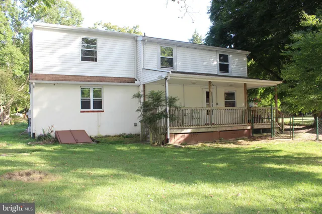 a view of a white house with a big yard and a large tree