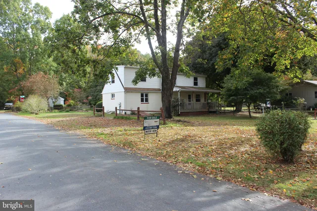 a view of a house with a yard and large tree