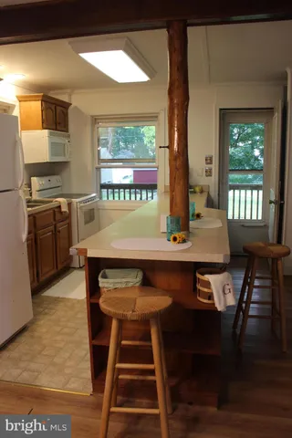 a kitchen with stainless steel appliances a refrigerator a table and chairs