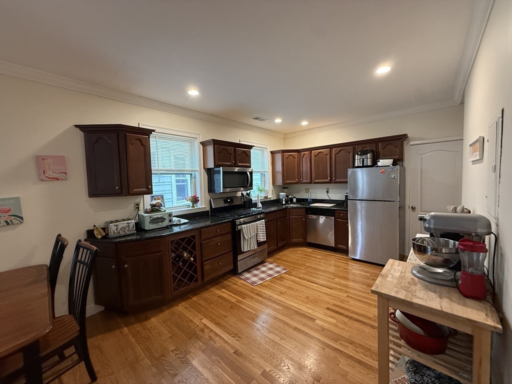 106 Chester Street, Unit 2 Boston, MA 02134 - Photo 3 of 9 a kitchen with stainless steel appliances granite countertop a refrigerator stove microwave and sink