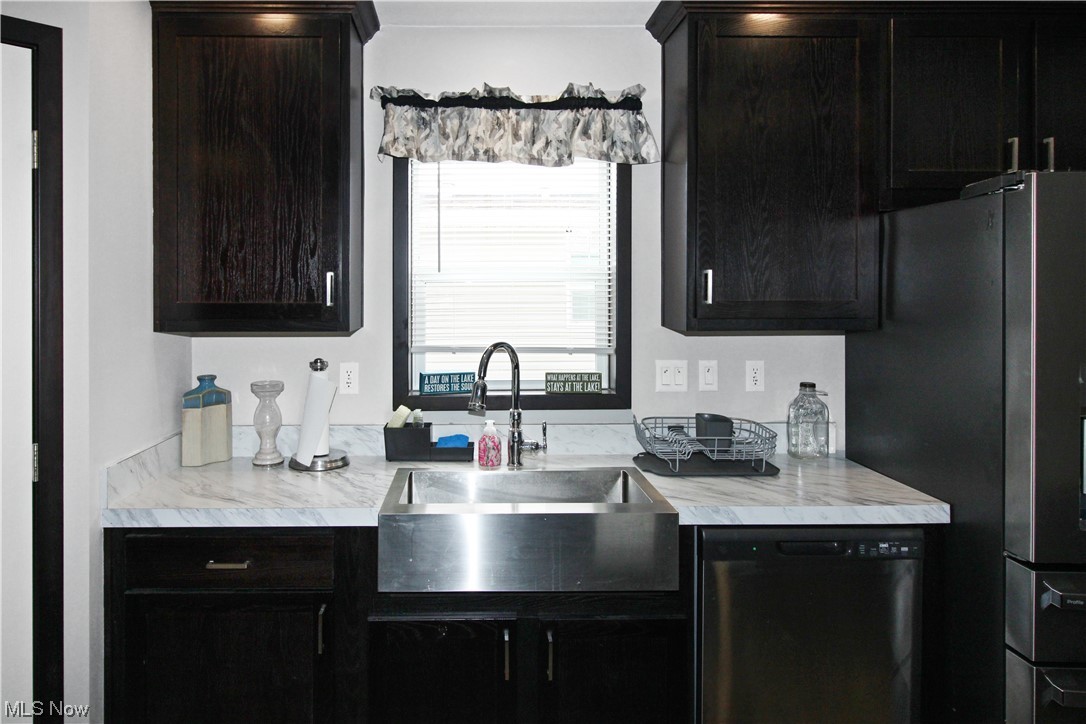 1609 Coldwater Crossing Road Lakeside Marblehead, OH 43440 - Photo 18 of 38 Kitchen with appliances with stainless steel finishes, dark brown cabinetry, and sink