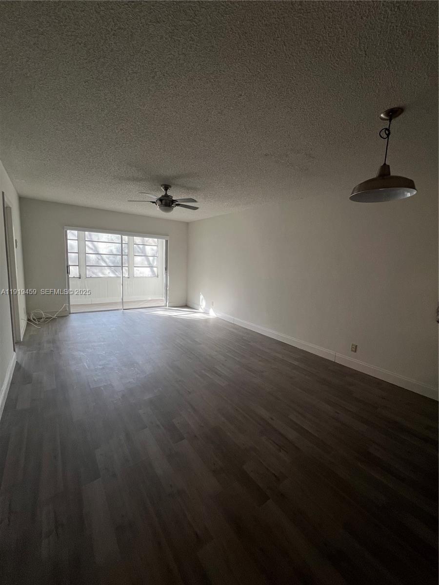 301 Cambridge Road, Unit 211 Hollywood, FL 33024 - Photo 17 of 33 a view of wooden floor and windows in an empty room