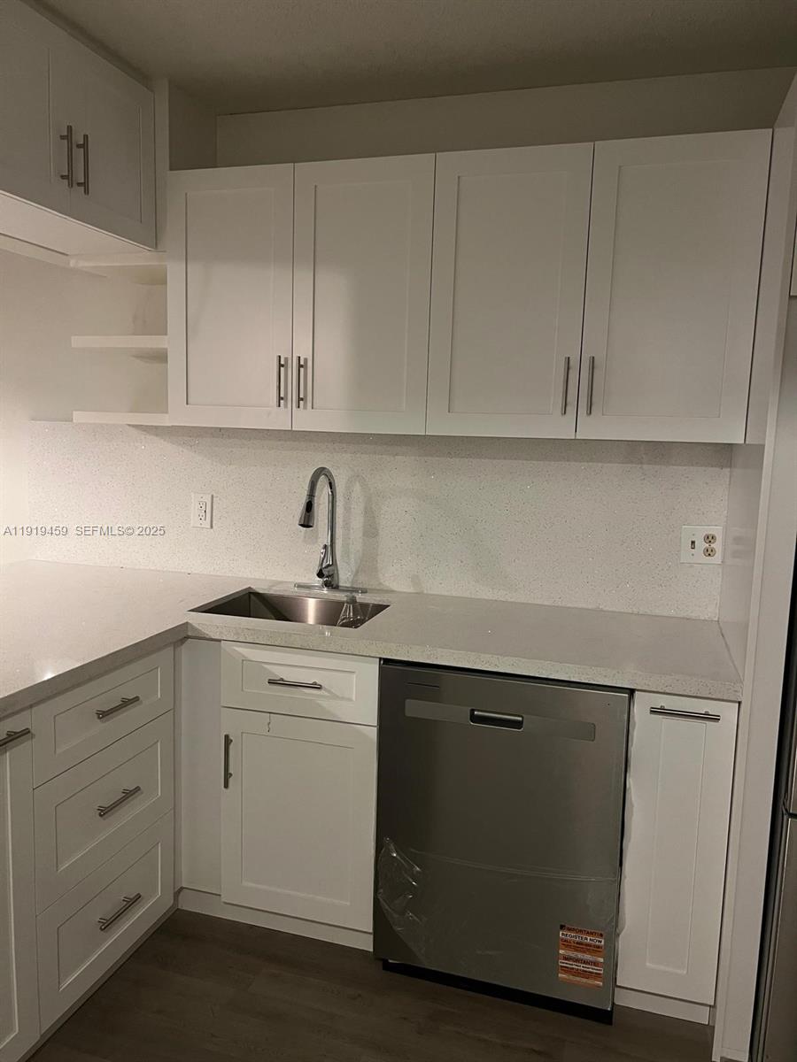 301 Cambridge Road, Unit 211 Hollywood, FL 33024 - Photo 25 of 33 a kitchen with white cabinets and a sink