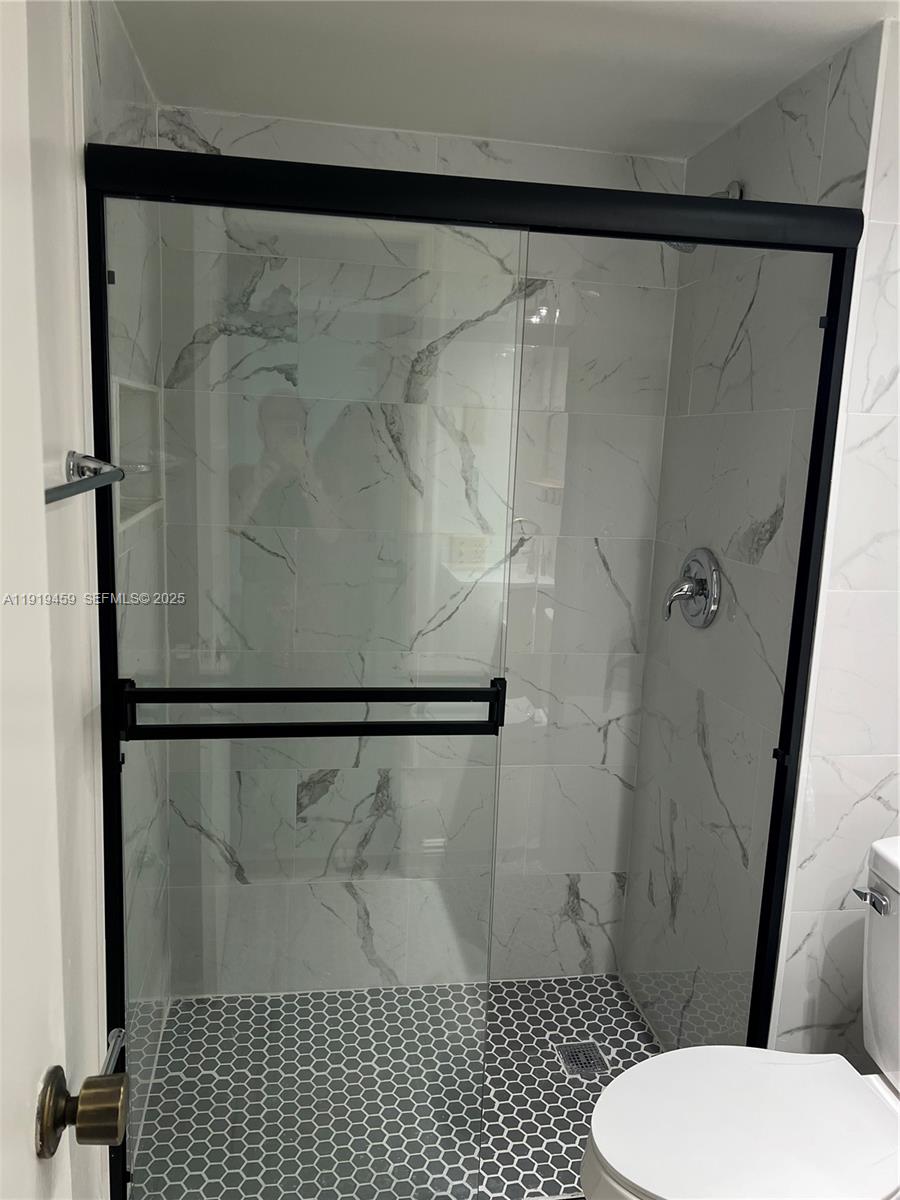 301 Cambridge Road, Unit 211 Hollywood, FL 33024 - Photo 27 of 33 a bathroom with a shower toilet and sink