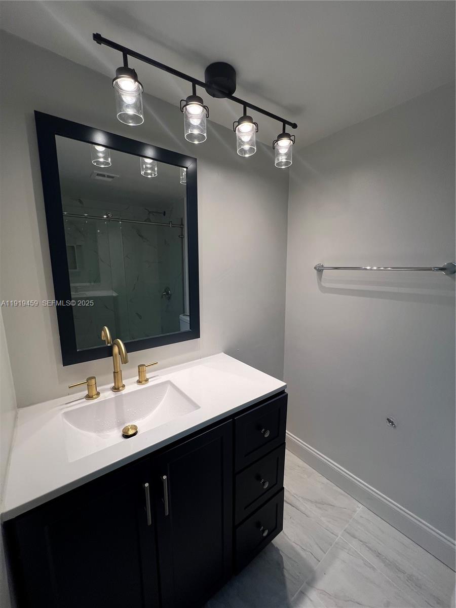 301 Cambridge Road, Unit 211 Hollywood, FL 33024 - Photo 29 of 33 a bathroom with a sink vanity and mirror