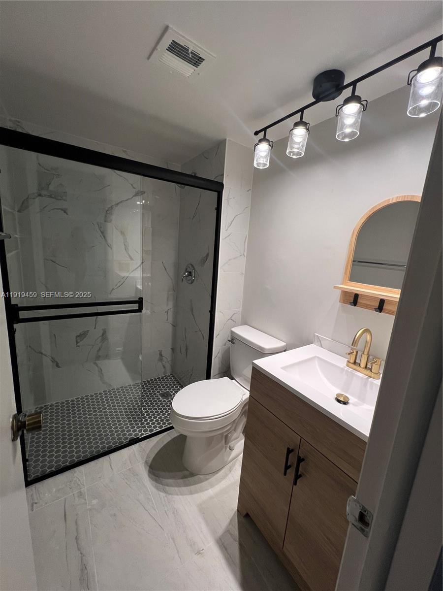 301 Cambridge Road, Unit 211 Hollywood, FL 33024 - Photo 30 of 33 a bathroom with a sink a toilet and shower