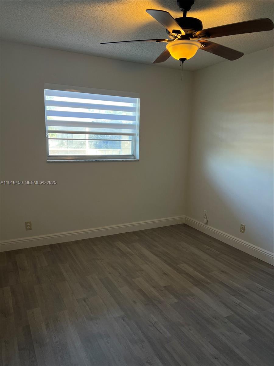 301 Cambridge Road, Unit 211 Hollywood, FL 33024 - Photo 33 of 33 a view of empty room with wooden floor and fan