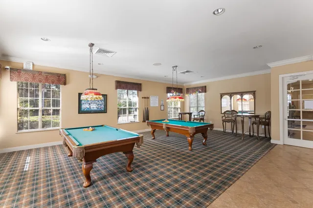 a living room with furniture a pool table and a large window