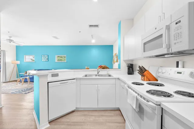 a kitchen with a sink cabinets and wooden floor