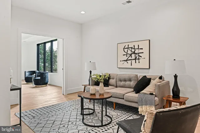 a view of empty room with wooden floor and kitchen