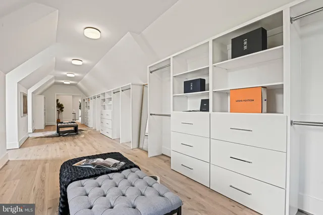 a view of an empty room with wooden floor and stairs