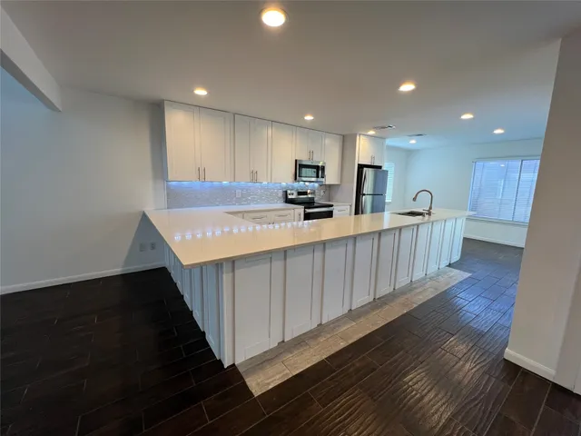 a kitchen with kitchen island granite countertop wooden cabinets a sink and dishwasher