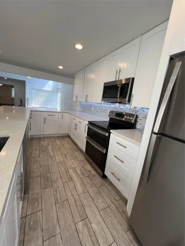 a kitchen with a sink stainless steel appliances and cabinets