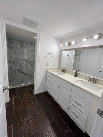 a bathroom with a double vanity sink and mirror