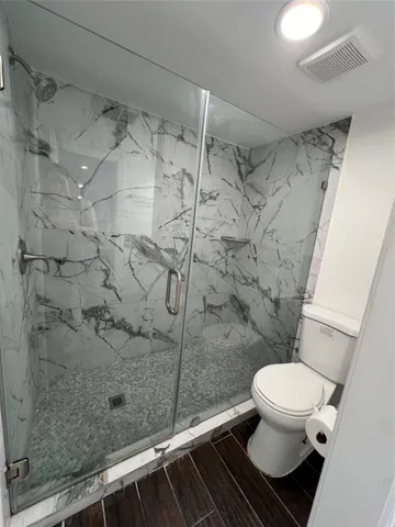 a bathroom with a toilet and a shower