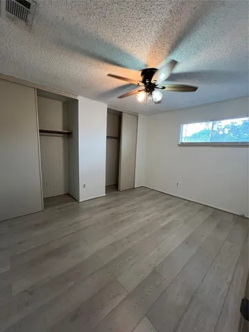a view of an empty room with a ceiling fan