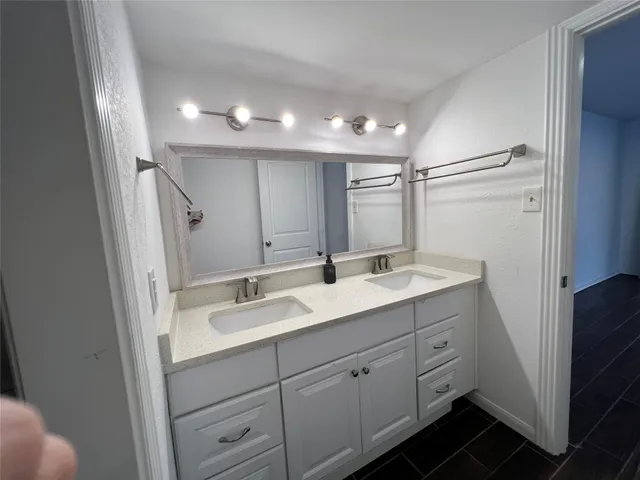 a bathroom with a double vanity sink and mirror