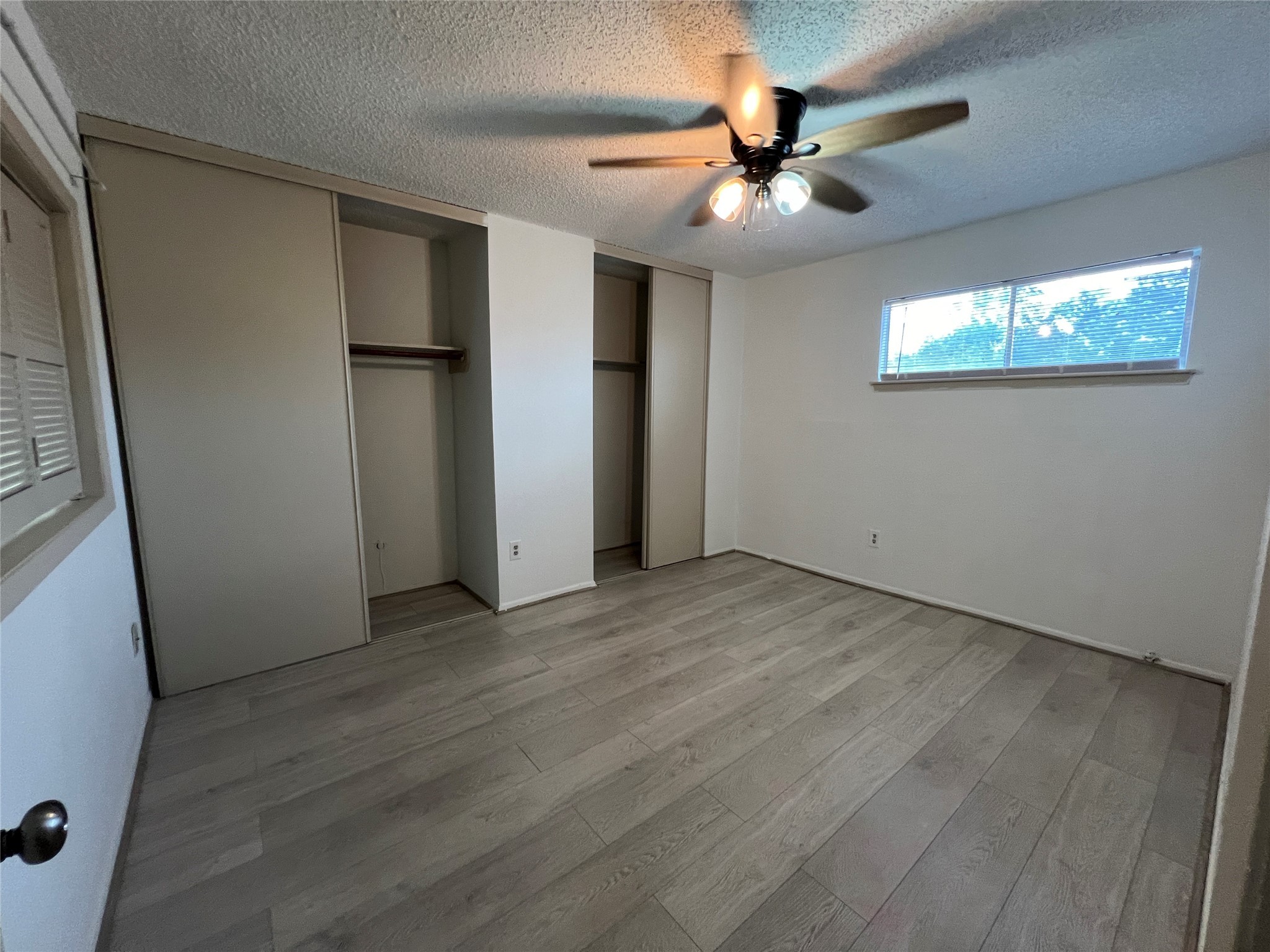 2372 Woodland Park Drive, Unit 121 Houston, TX 77077 - Photo 41 of 47 an empty room with wooden floor fan and windows