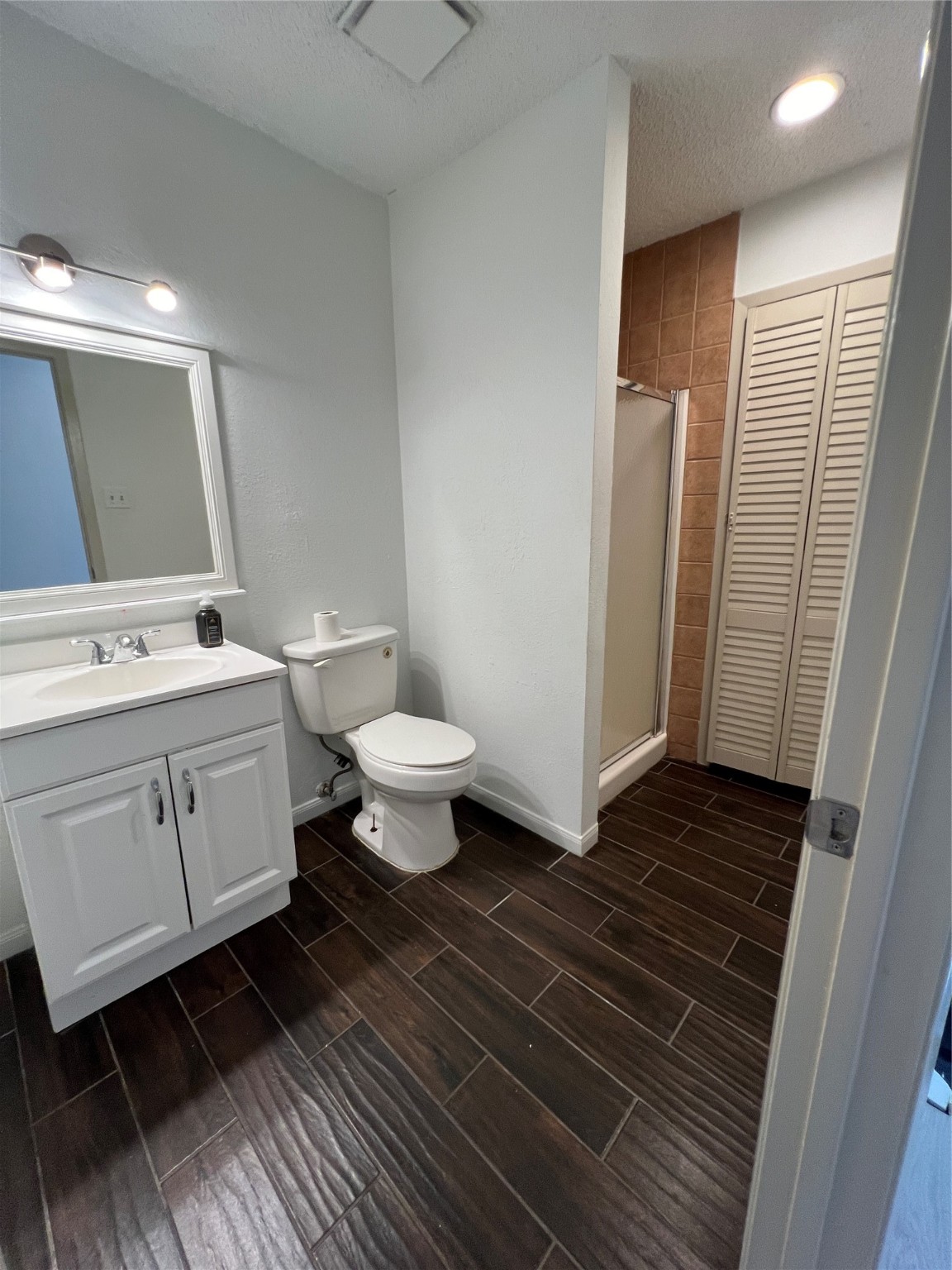 2372 Woodland Park Drive, Unit 121 Houston, TX 77077 - Photo 43 of 47 a bathroom with a sink toilet a mirror and vanity