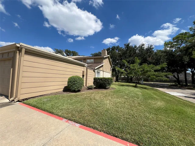 a view of a house with backyard and trees