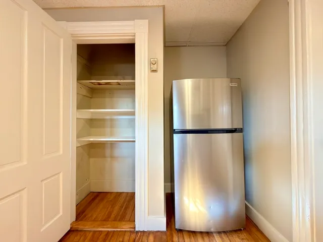a view of a room with wooden floor and cabinet