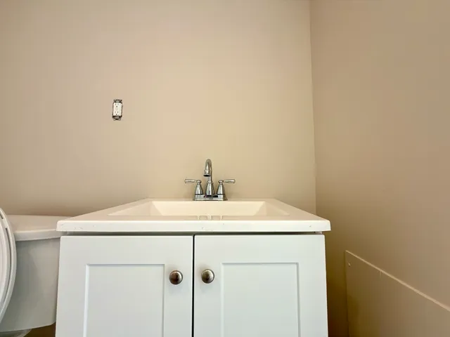 a utility room with a sink a vanity and a mirror