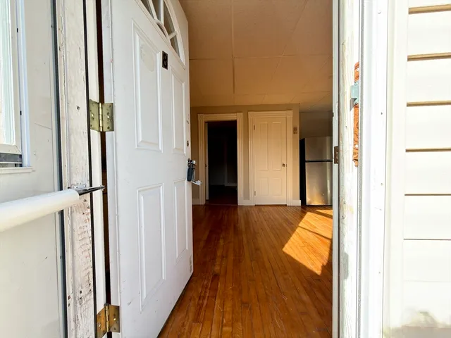 a view of a hallway with wooden floor and staircase