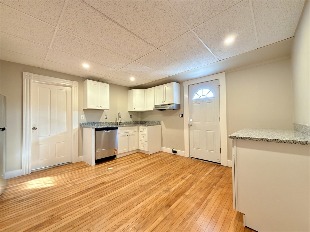91 Alvarado Avenue, Unit 8 Worcester, MA 01604 - Photo 6 of 26 a open kitchen with white cabinets and wooden floor
