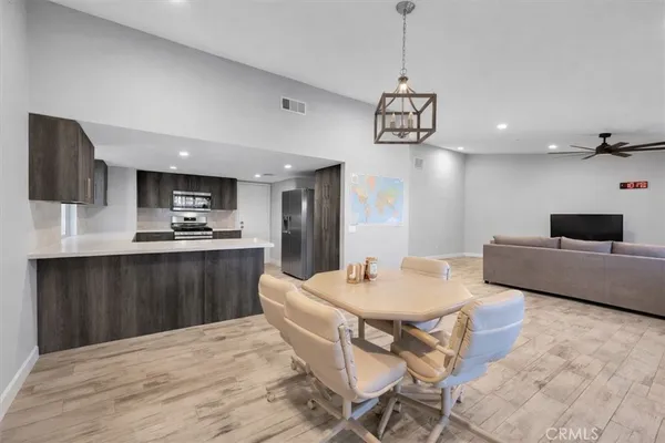 a kitchen with a dining table chairs and refrigerator