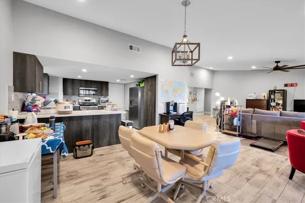 a dining room with kitchen island stainless steel appliances furniture a dining table and chairs
