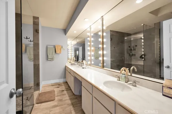 a bathroom with a double vanity sink a mirror and a shower