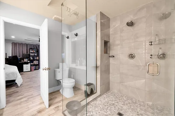 a bathroom with a granite countertop shower a toilet and a sink