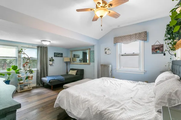 a bedroom with a bed and wooden floor