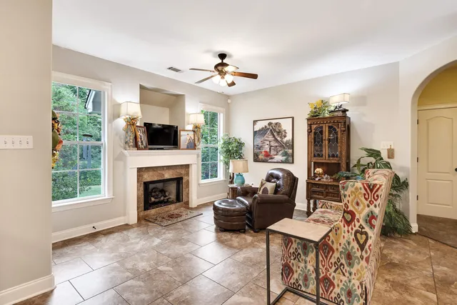 a living room with furniture a fireplace and a flat screen tv